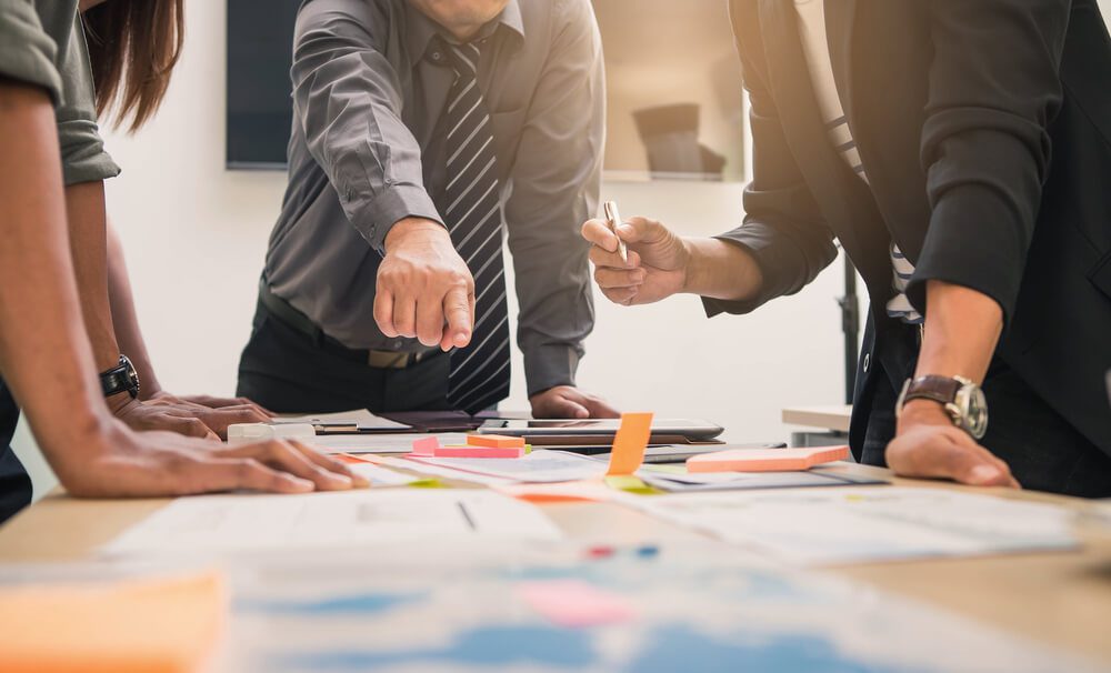 Why Smart SaaS Marketers Invest in Whitepapers and eBooks 4 marketing plan_Brainstorming Group of people Working Concept. Business team brainstorming. Marketing plan researching. Paperwork on the table, laptop and mobile phone.