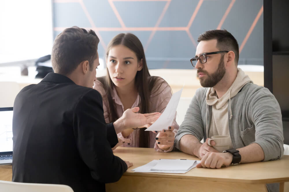 client demand_Angry millennial couple complaining having claims about bad contract terms disputing at meeting with lawyer, deceived dissatisfied customers demanding compensation, legal fight and fraud concept