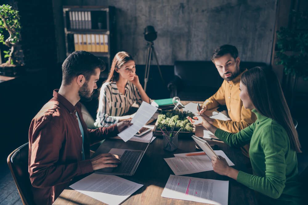 case study_Serious experienced businesspeople wearing casual formal-wear discussing preparing law case contract tender assignment agreement at modern industrial loft brick style interior work place station