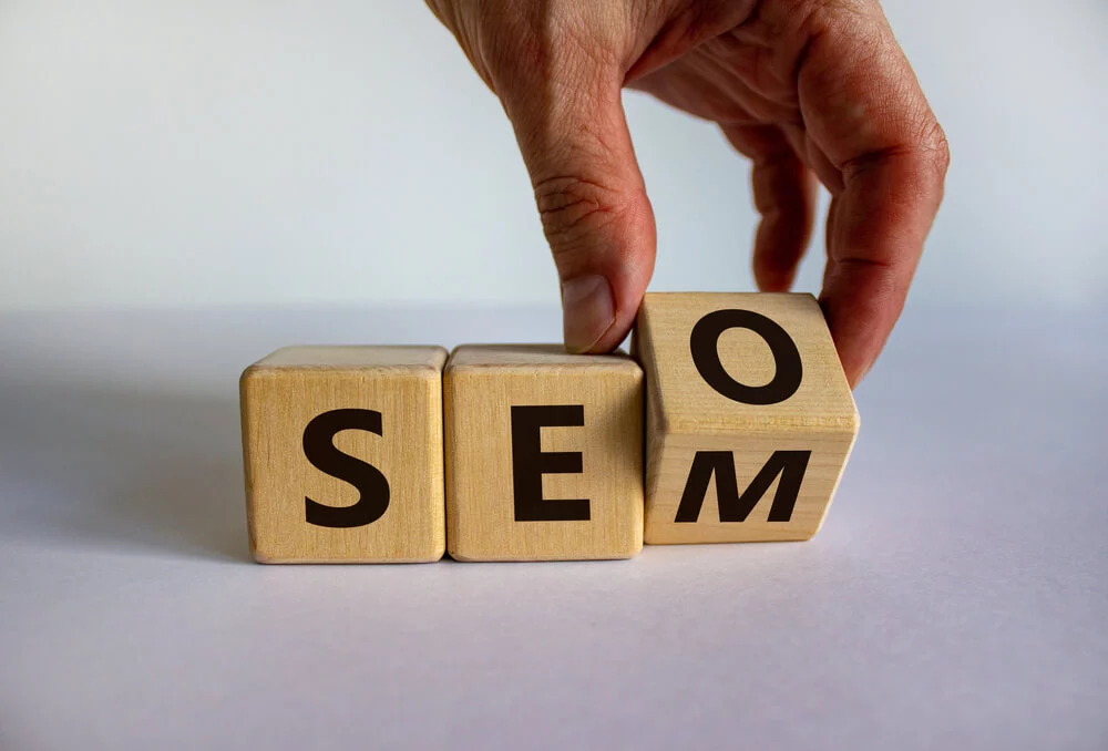 seo vs sem_SEO vs SEM. Male hand turns a cube and changes the expression 'SEO' to 'SEM', vice versa. Concept for SEO and SEM or Search Engine Optimization and Search Engine Matketing. Beautiful white background