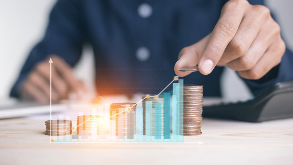 profit_businessman holding coins putting in glass. concept saving money for finance accounting to arrange coins into growing graphs concept.