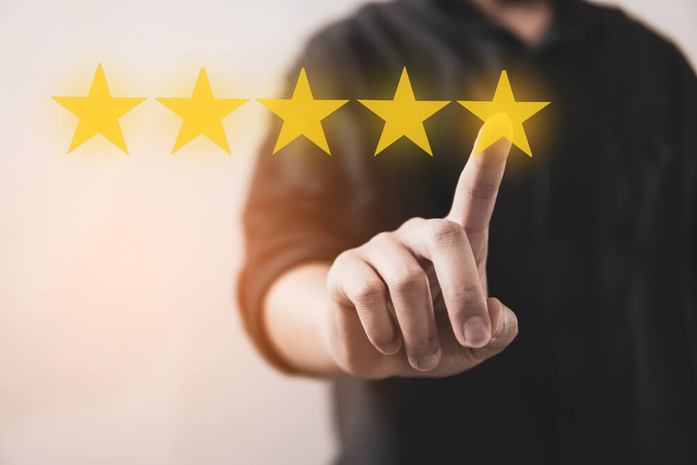 reviews_Customer review good rating concept hand pressing five star on visual screen and positive customer feedback testimonial