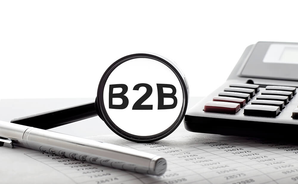 B2B SEO_Magnifying glass with text B2B on the chart with pen and calculator