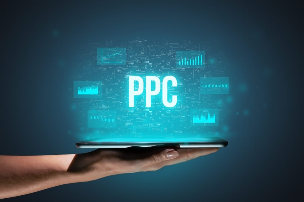 ppc strategy_Concept PPC or Pay per click. Business acronym. Holographic icons and text over tablet in hands.