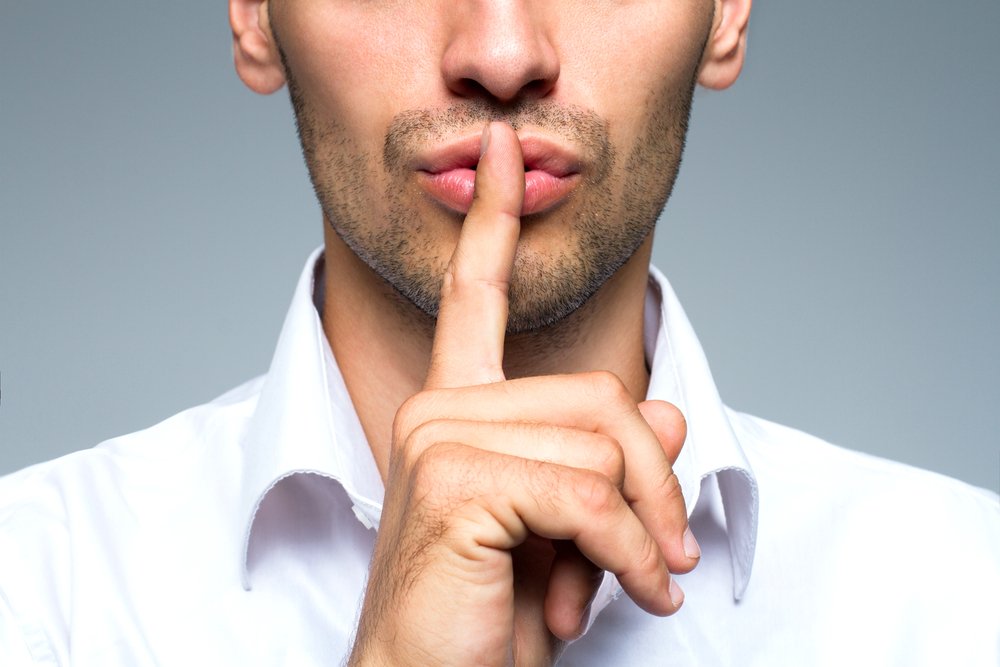 business secret_Businessman silent quiet gesture with finger