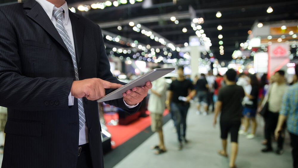 marketing event_businessman using tablet with blurred event background