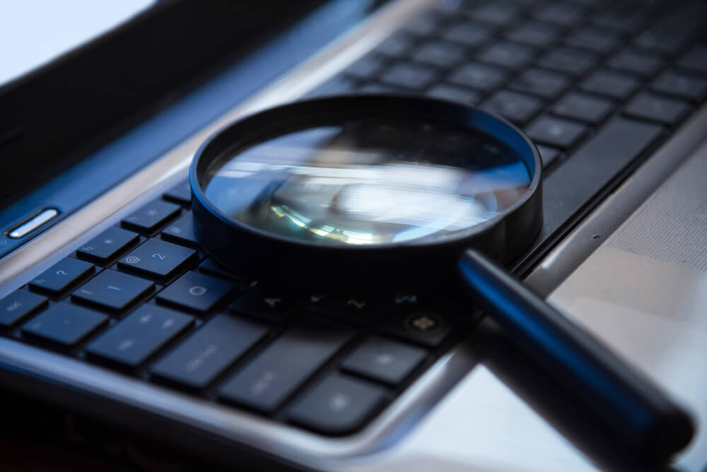 SEO_Selective focus on keyboard with magnifier searching concept in dark low key night tone