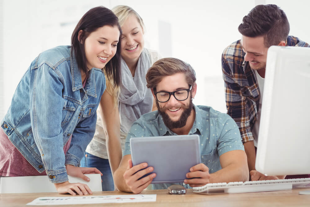 Keeping PPC Management Fees Affordable: Choose Your Billing Structure 2 digital agency_Smiling business people using digital tablet at computer desk in office