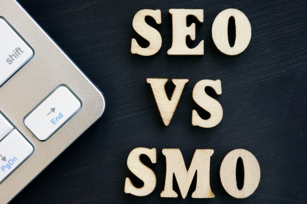 seo vs smo_SEO vs SMO and keyboard on a dark desk.
