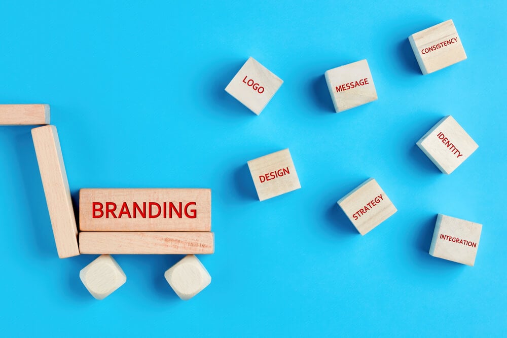 brand consistency_The concept of branding and its essential elements written on wooden blocks on blue background. Concept of product or service branding in business.