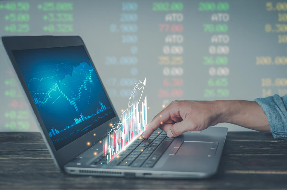 data_Young money businessman sitting staring at a computer screen displaying a crypto currency featuring stock tickers or graphs. Stock trading platform concept. professional financial advisor.