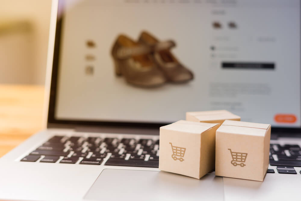 website consumer_Online shopping - Paper cartons or parcel with a shopping cart logo on a laptop keyboard which web store shop on screen, Shopping service on The online web and offers home delivery.