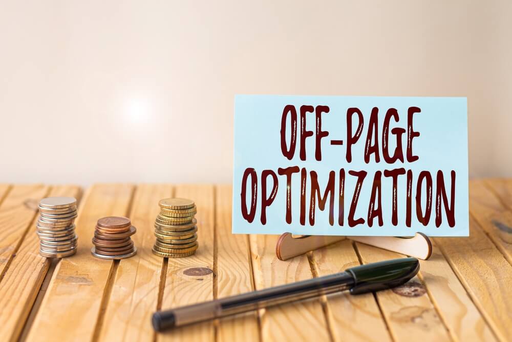 off page optimization_Writing displaying text Off Page Optimization. Word Written on Website External Process Promotional Method Ranking Empty Piece Of Paper On Holder Beside Stockpile Coins Over Desk With Pen