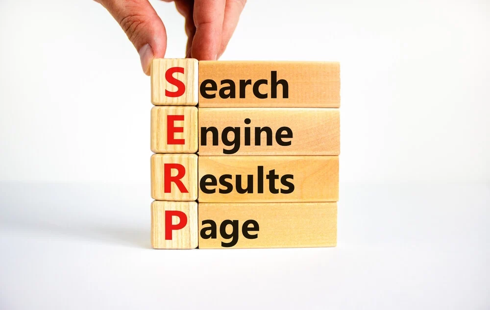 SERP_SERP symbol. Abbreviation SERP search engine results page on wooden blocks. Beautiful white background. Businessman hand. Copy space. Business and SERP search engine results page concept.