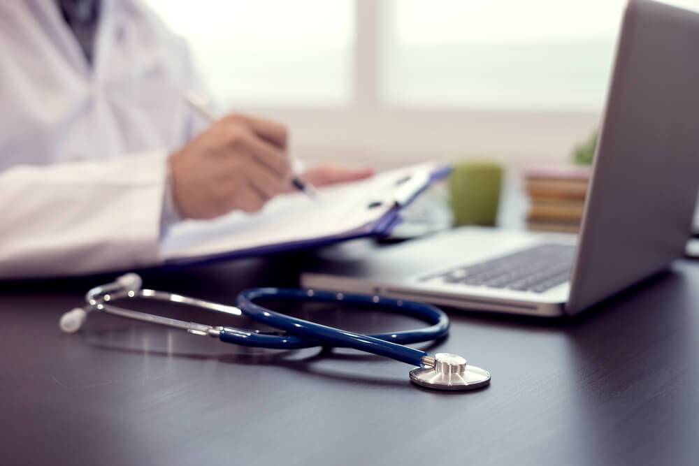medical practice_Stethoscope with clipboard and Laptop on desk,Doctor working in hospital writing a prescription, Healthcare and medical concept,test results in background,vintage color,selective focus
