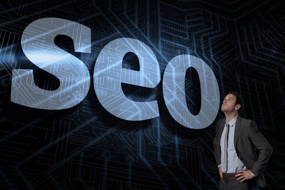 seo professional_The word seo and serious businessman with hands on hips against futuristic black and blue background