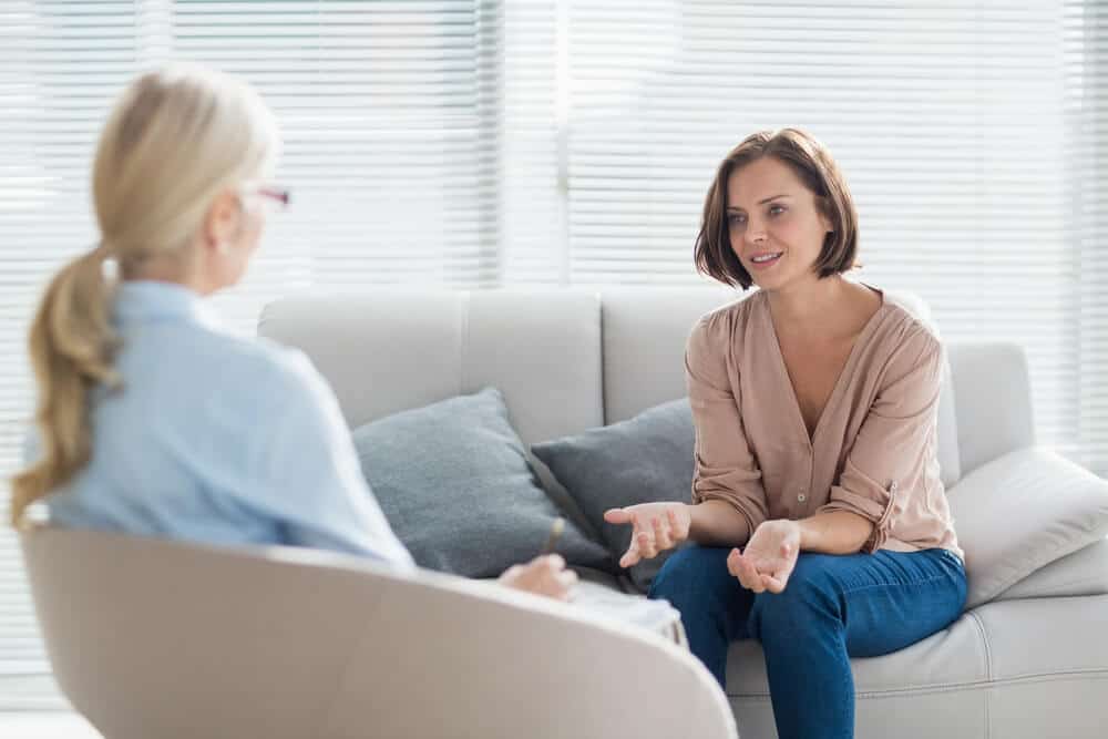 therapist_Woman talking to therapist on sofa at home