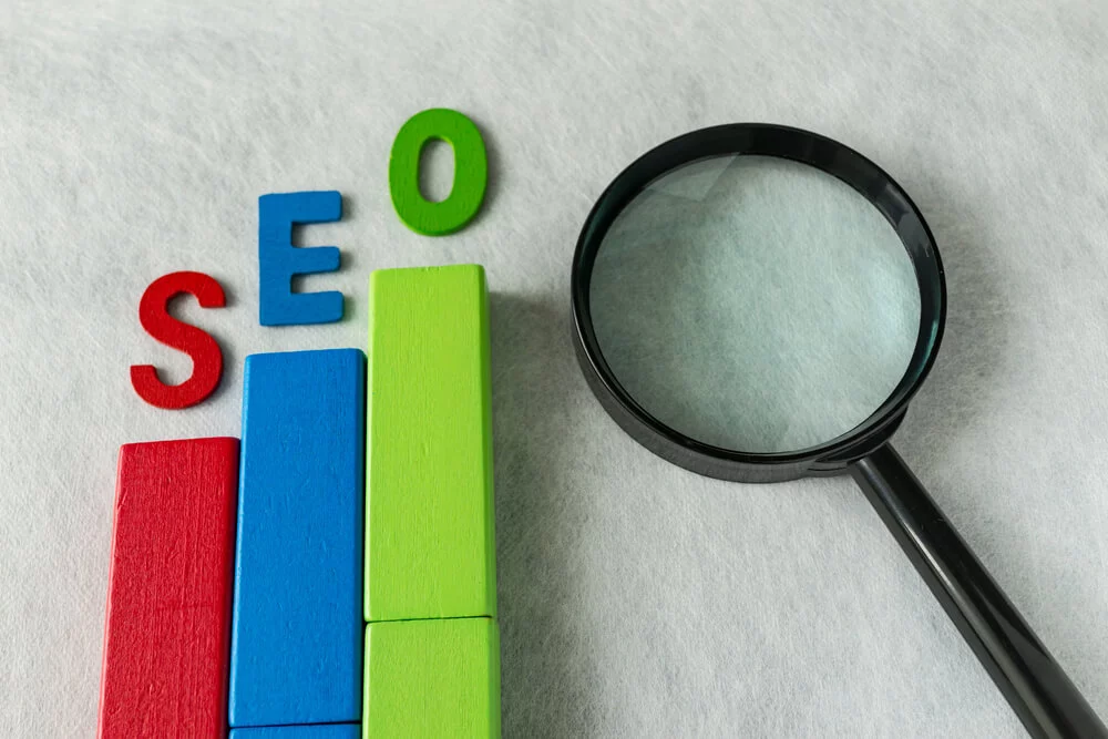 seo rankings_SEO Search engine optimization concept as colorful wooden block as analysis chart with alphabet abbreviation SEO and magnification glass on white texture paper.