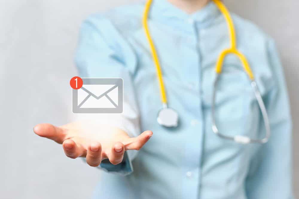 healthcare email_Doctor holds an abstract email with a hand in his hand.