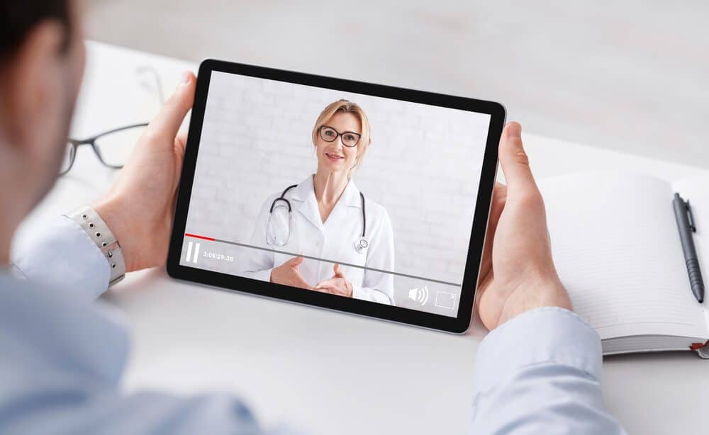 content marketing for health_Health blog. Man in shirt watching medical video with woman doctor on tablet, panorama, free space