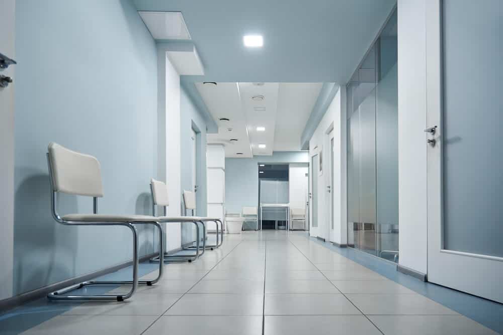 clinic_Empty modern hospital corridor, clinic hallway interior background with white chairs for patients waiting for doctor visit. Contemporary waiting room in medical office. Healthcare services concept
