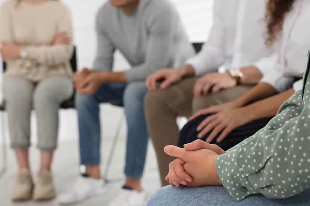 drug rehabilitation centre_People at group therapy session indoors, closeup