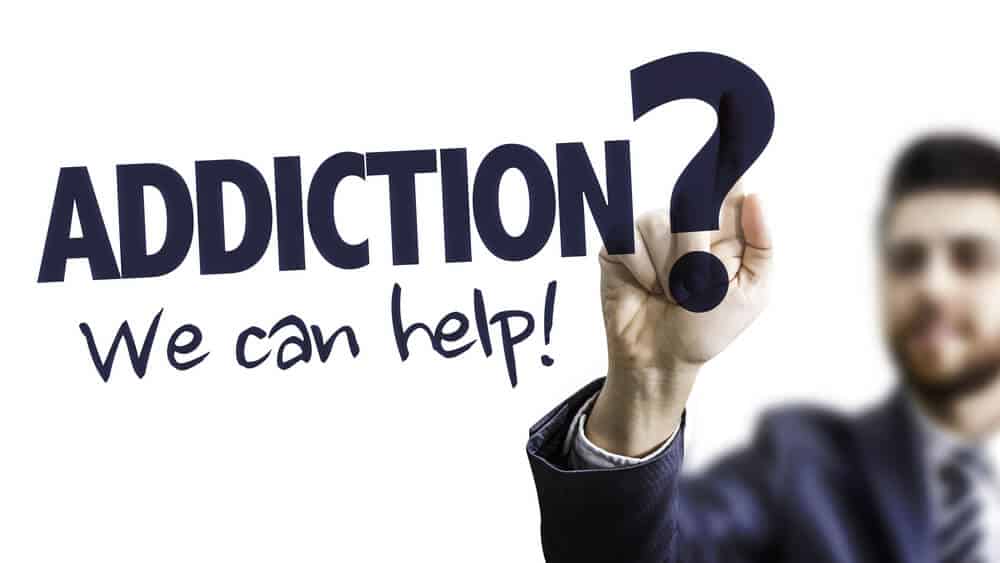 drug rehabilitation_Business Man Pointing the Text: Addiction? We Can Help!