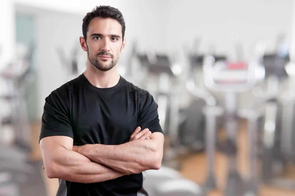 personal trainer_Personal trainer with is arms crossed, in a gym