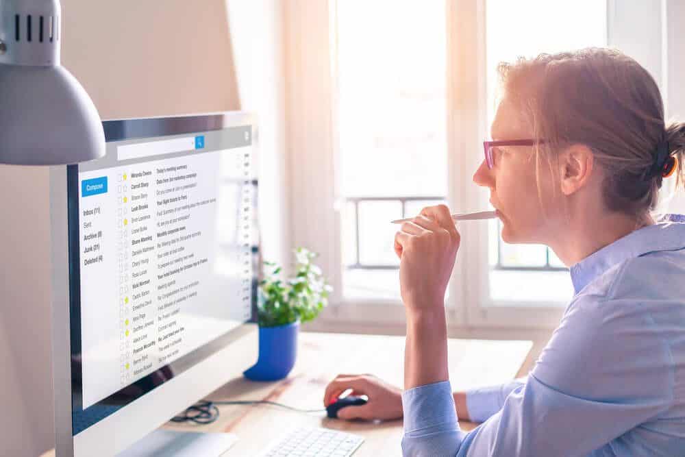 email marketing_Female business person reading email on computer screen at work on internet