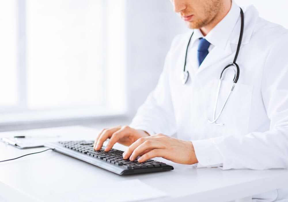 healthcare email_close up of male doctor typing on the keyboard