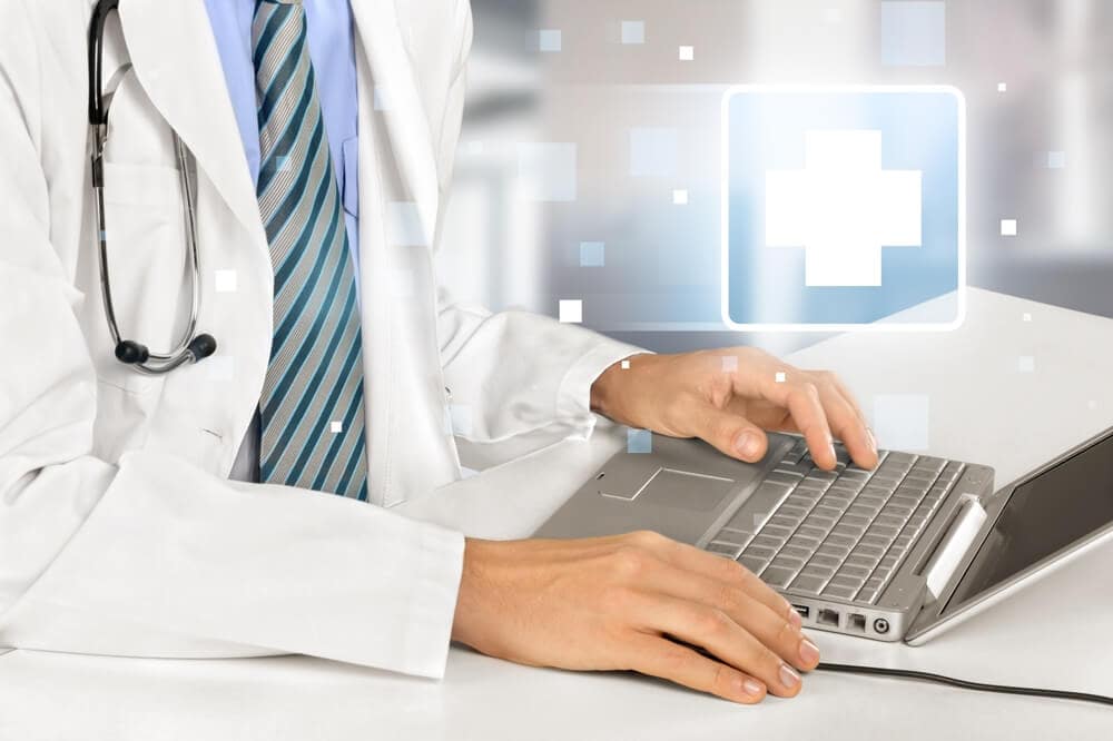 healthcare email_Modern tech for healthcare. Doctor sit at desk use laptop watch professional training webinar online manage electronic medical document.