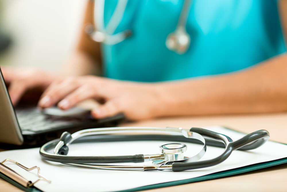 healthcare email_close up of female doctor working with laptop