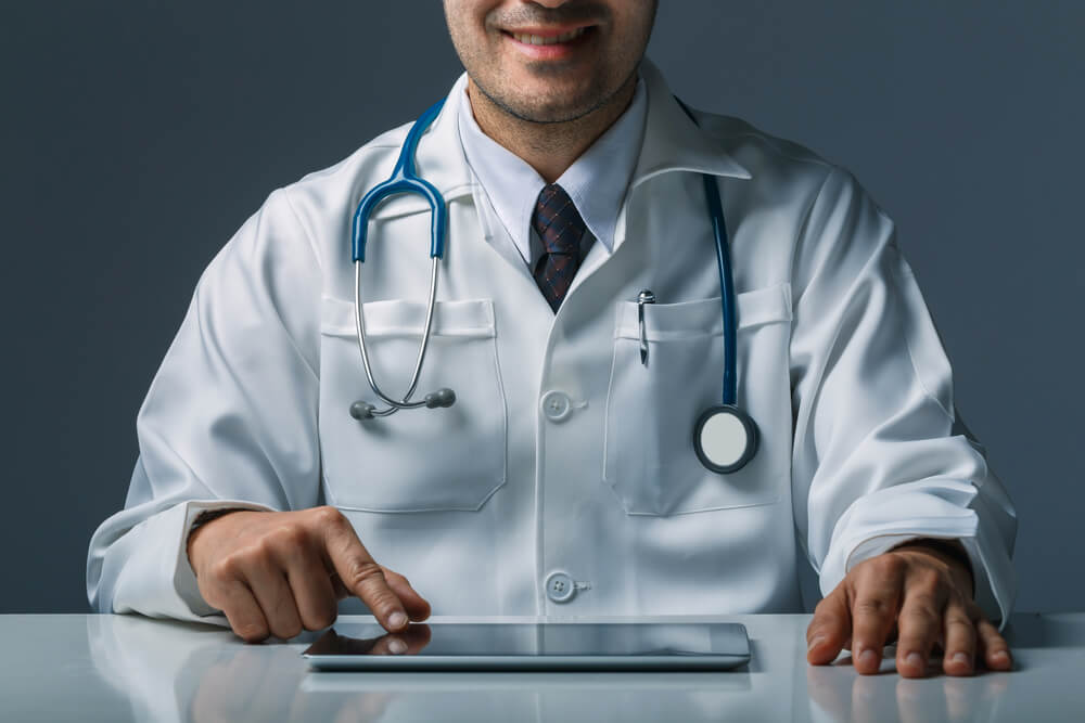 healthcare content_Asian smart doctor holding tablet computer with hand. Surgeon has stethoscopes. concept of medical live in social online.