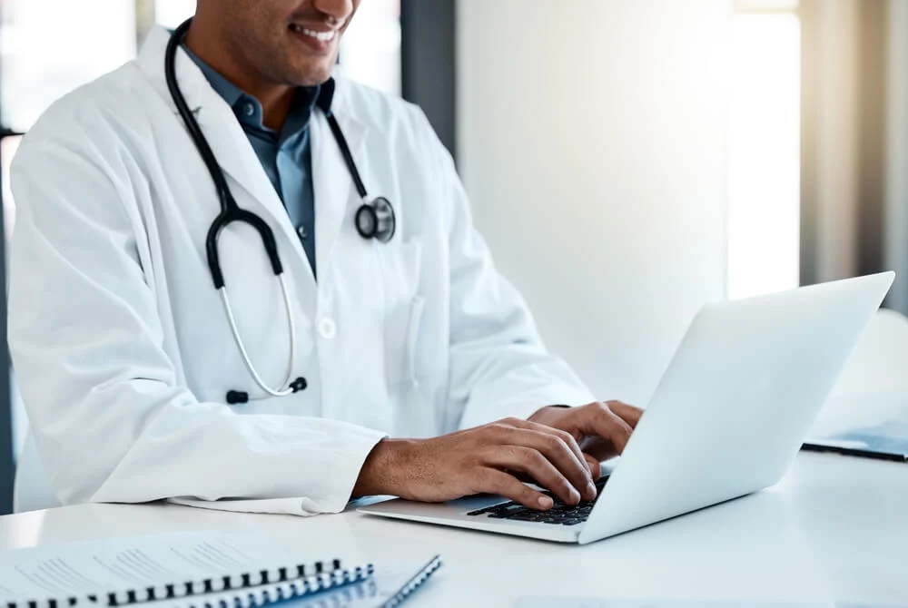 healthcare email_Doctor, laptop and typing email or online medical prescription for healthcare treatment plan. Hospital, clinic and male physician or specialist browsing digital medicine data or information