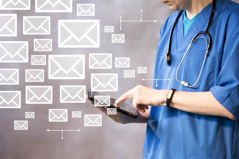 health email_Doctor pushing button on tablet to send mail business network