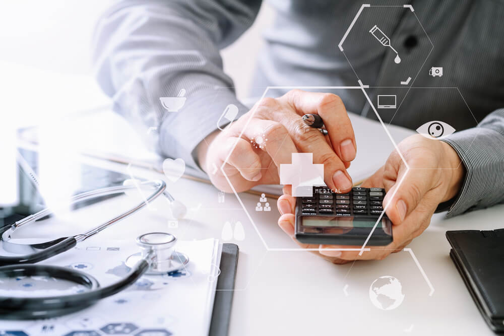 healthcare cost_Healthcare costs and fees concept.Hand of smart doctor used a calculator for medical costs in modern hospital with VR icon diagram
