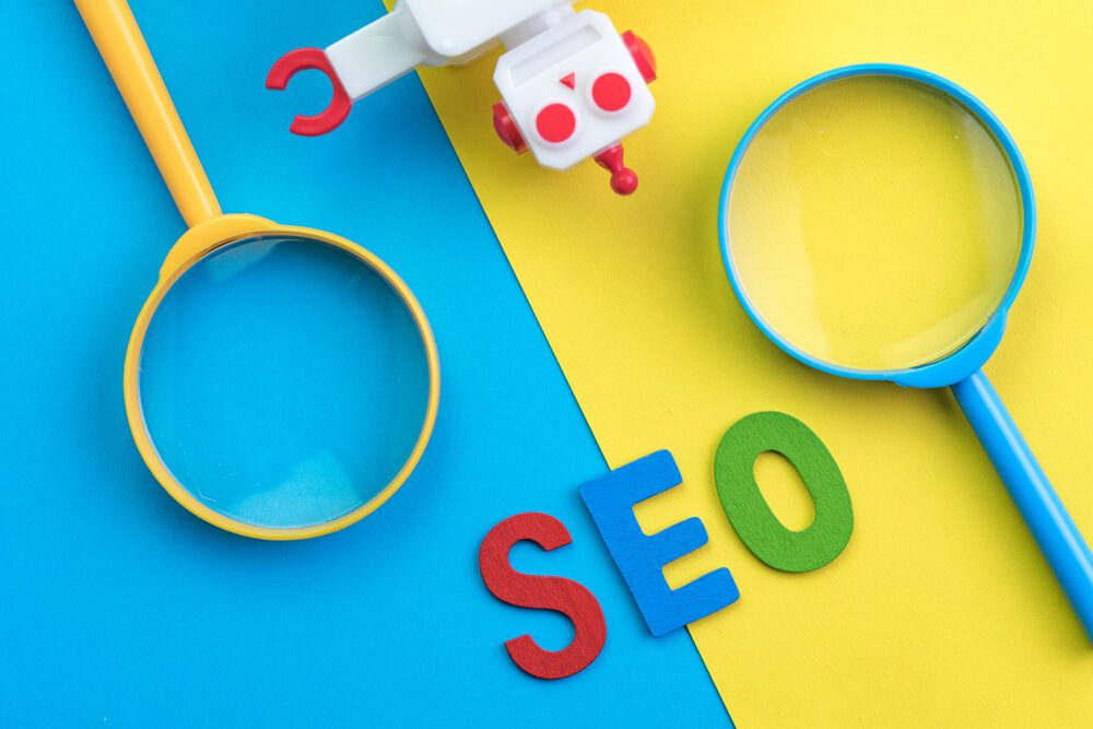 seo_SEO Search engine optimization concept with blue and yellow magnifying glass, alphabet abbreviation SEO and robot on colorful background.