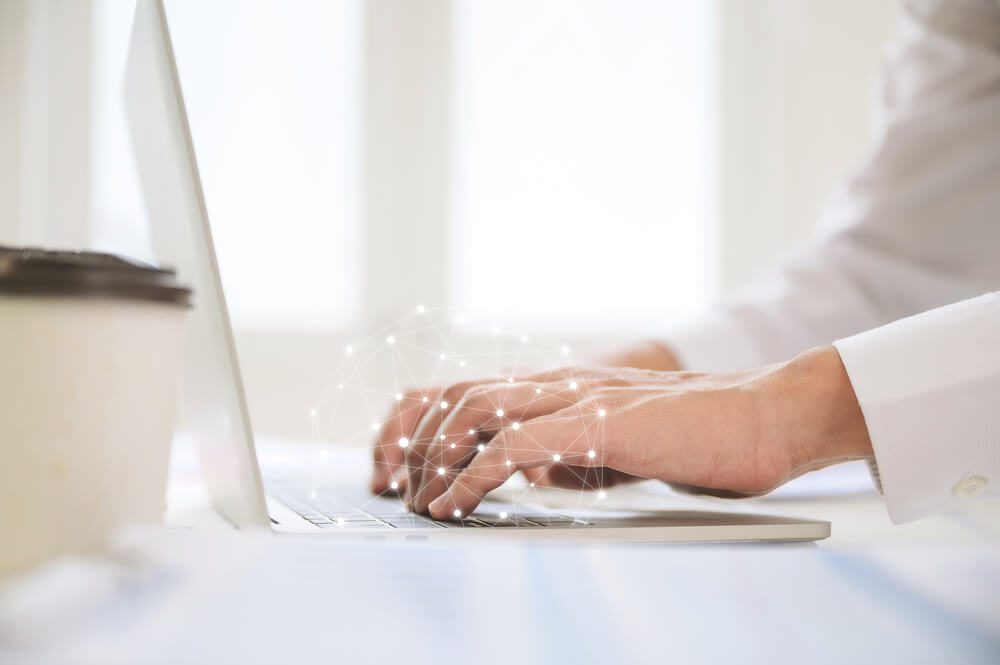 AI or SEO_Close up image of businessman hands working computer laptop on desk in office room