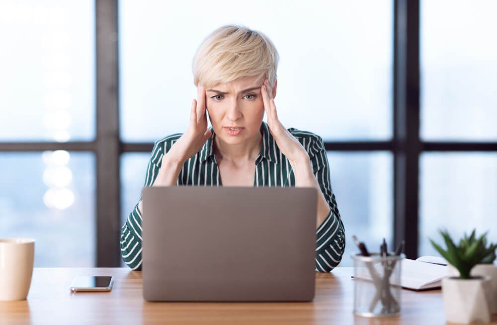 seo issues_Stressful Job. Overworked Business Woman Having Headache Massaging Temples Sitting At Laptop In Modern Office. Selective Focus