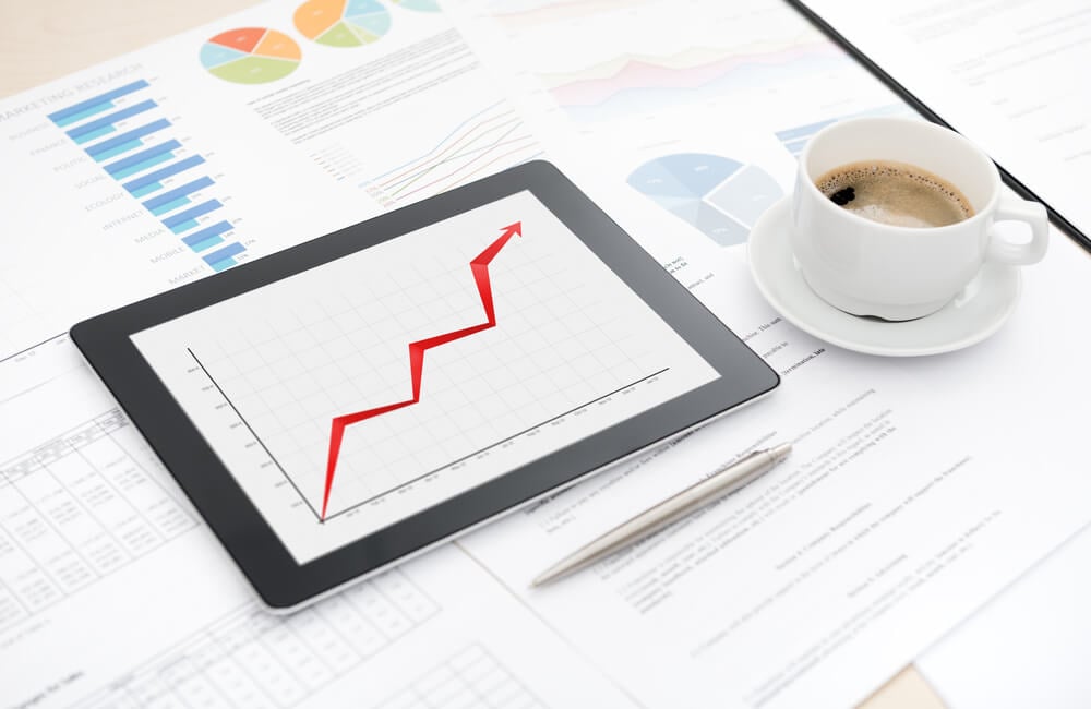 seo business growth_Desktop with success business report on a modern digital tablet, some papers with charts and graphs and with a cup of coffee.