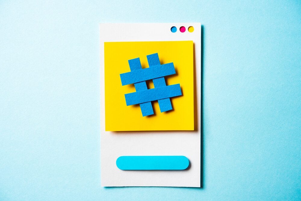 seo trends_Hashtag symbol post note with paper smart phone concept on blue background. Social media and digital marketing concept. Concept of social media trends.