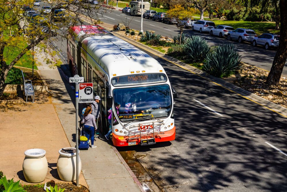 San Diego bus_March 19, 2019 San Diego / CA / USA - People getting on a bus at Balboa Park stop