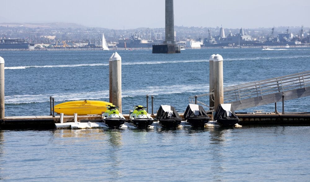 jetski in san diego_San Diego, CA USA - March 14, 2021: Jet skis and kayaks for rent at a doc station with ramp on the San Diego, Coronado Bay area in California. USA