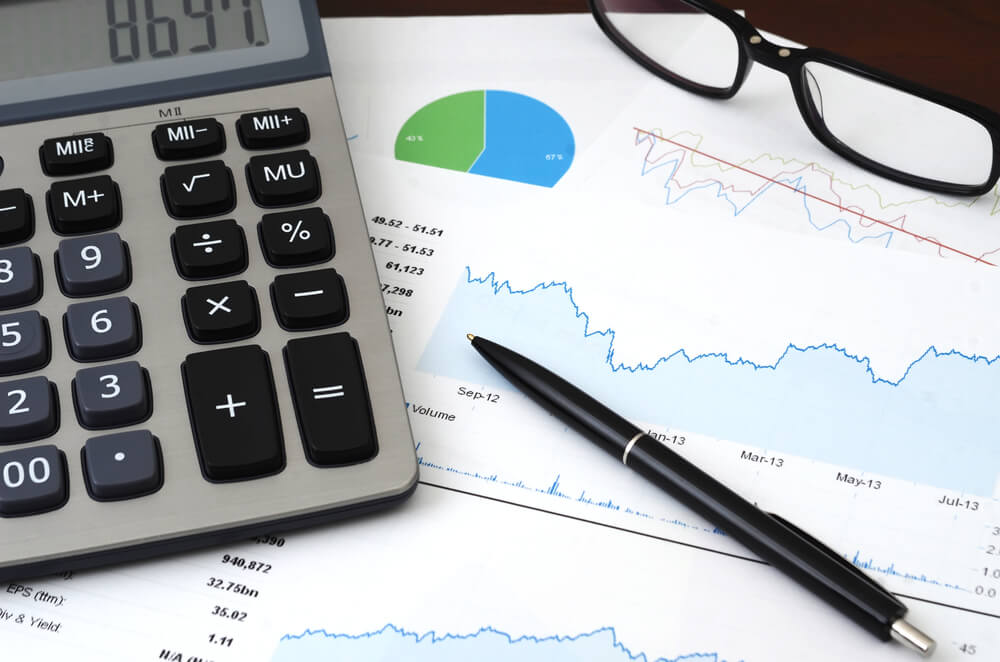 seo budget_Financial Planning or SEO (Internet marketing) Concept - Sales or Visitors Report and Graphs Analysis. Colorful sales charts, graph, calculator, pen and glasses.