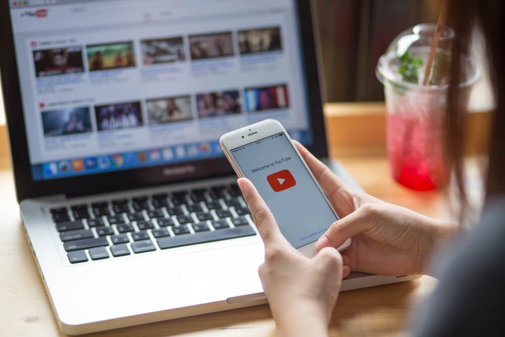 youtube_THAILAND - July 20, 2017 :Woman holding iPhone with video service YouTube on the screen. iPhone was created and developed by the Apple inc.