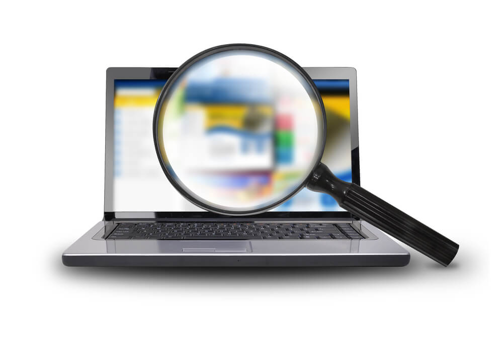 on-site search_A computer laptop is isolated on a white background with a magnifying glass searching the internet.