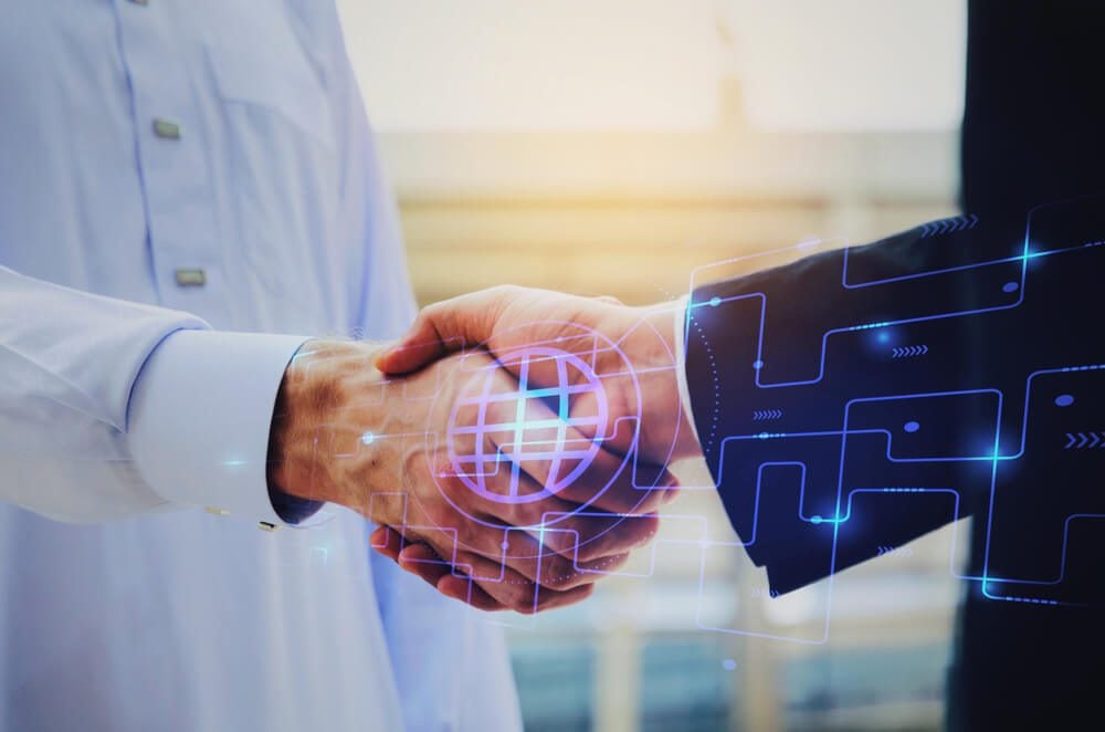 digital agency_close up hand of young Arabian man in white suit handshake after finishing up meeting with graphic network diagram, partnership, teamwork, technology, connection, financial and investment concept