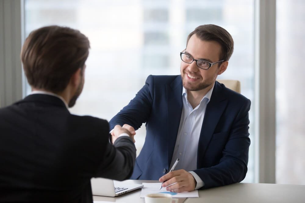 hire marketing_Smiling hr manager advisor insurer bank executive handshaking client applicant at meeting or job interview, satisfied businessmen shake hands thanking for good financial business deal, hiring concept