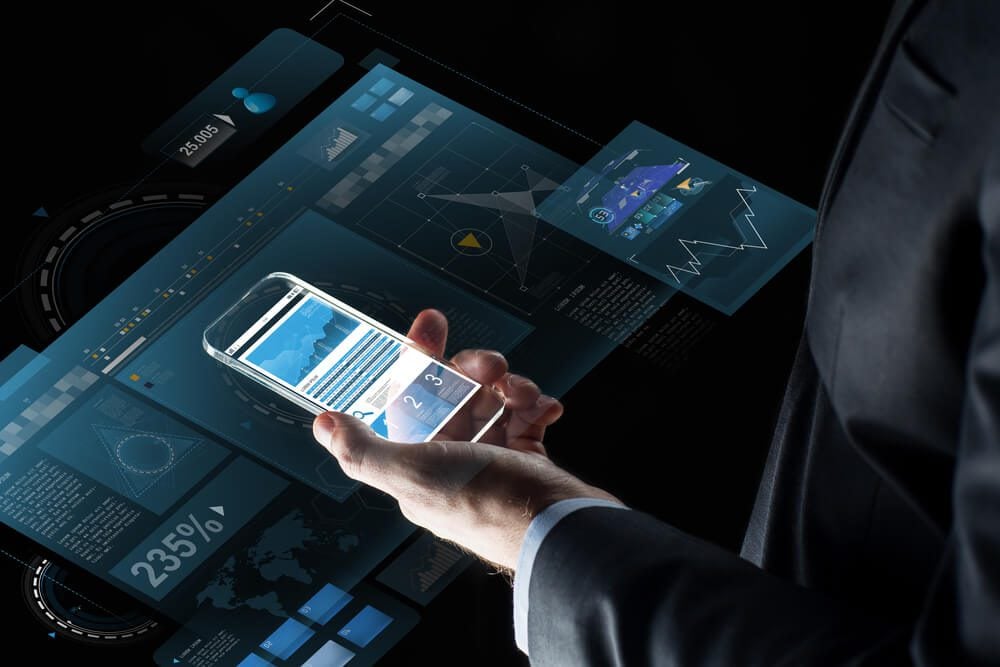mobile app_business, statistics, people and future technology concept - close up of businessman hand with charts on transparent smartphone screen and virtual projections over black background