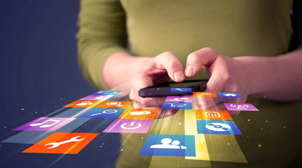What Features Do the Best B2B Mobile Apps Have? 1 mobile app_Woman holding smart phone with colorful application icons comming out